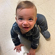 Xander is registered to the contest to win money with this photo: toddler, child, pajamas, floor, tile, crawling, smiling, happy, indoor, baby, person, cute, playing, small_object, holding, head, hands, eyes, mouth, clothing
