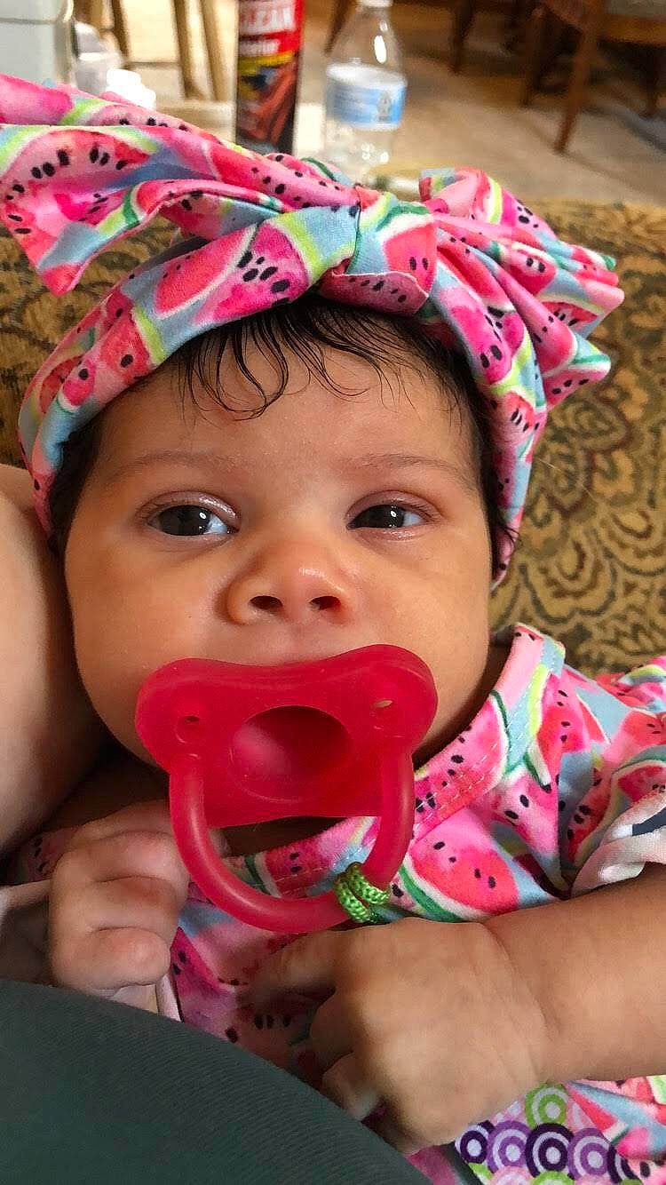 Kyla is registered to the contest to win money with this photo: baby, cheek, child, face, facial_expression, fashion_accessory, happy, headgear, lip, mouth, nose, person, pink, skin, smile, sun_hat, toddler, tongue