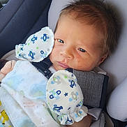 Brayzen is registered to the contest to win money with this photo: infant, baby, car_seat, blanket, mittens, face, person, clothing, child, young, cute, seated, indoors, soft_toys, patterned, comfort, resting, close_up, head, skin