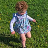 toddler, child, curly_hair, dress, long_sleeve, black_sneakers, grass, dandelions, outdoor, sunny, nature, greenery, walking, exploring, spring, field, young_child, casual_clothing, daylight, active