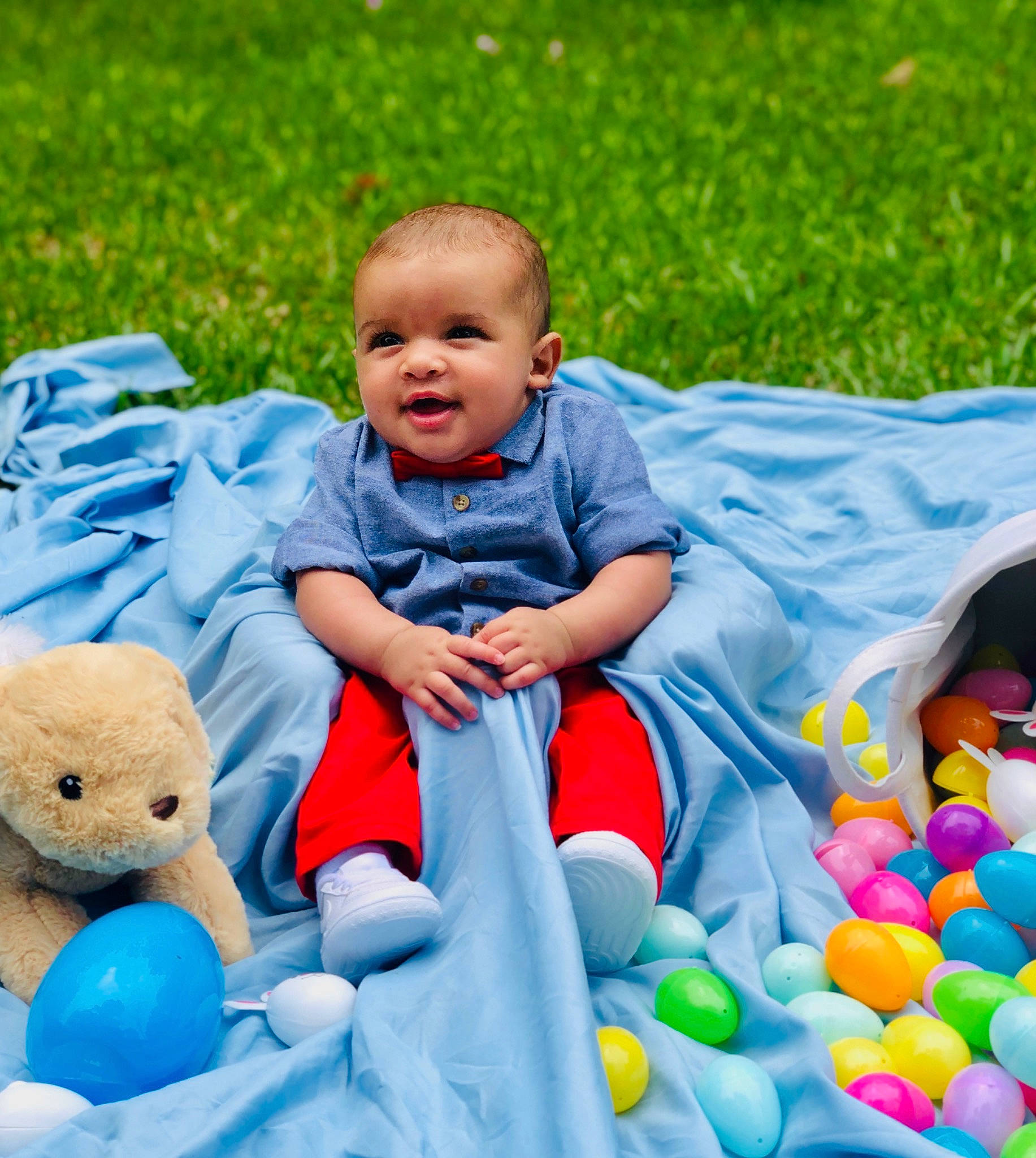 Kohen is registered to the contest to win money with this photo: baby, baby_playing_with_toys, blue, child, easter, fun, grass, happy, leisure, people, person, play, product, recreation, sitting, skin, smile, stuffed_toy, toddler, toy
