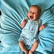Elias is registered to the contest to win money with this photo: baby, infant, blue_blanket, overalls, smiling, happy, cute, face, child, lying_down, clothing, texture, soft, skin, feet, hands, expression, indoors, portrait, young