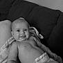 baby, infant, diaper, blanket, couch, smile, tongue_out, indoor, person, child, cute, relaxing, happy, expression, monochrome, black_and_white, soft_texture, human, sitting, comfort