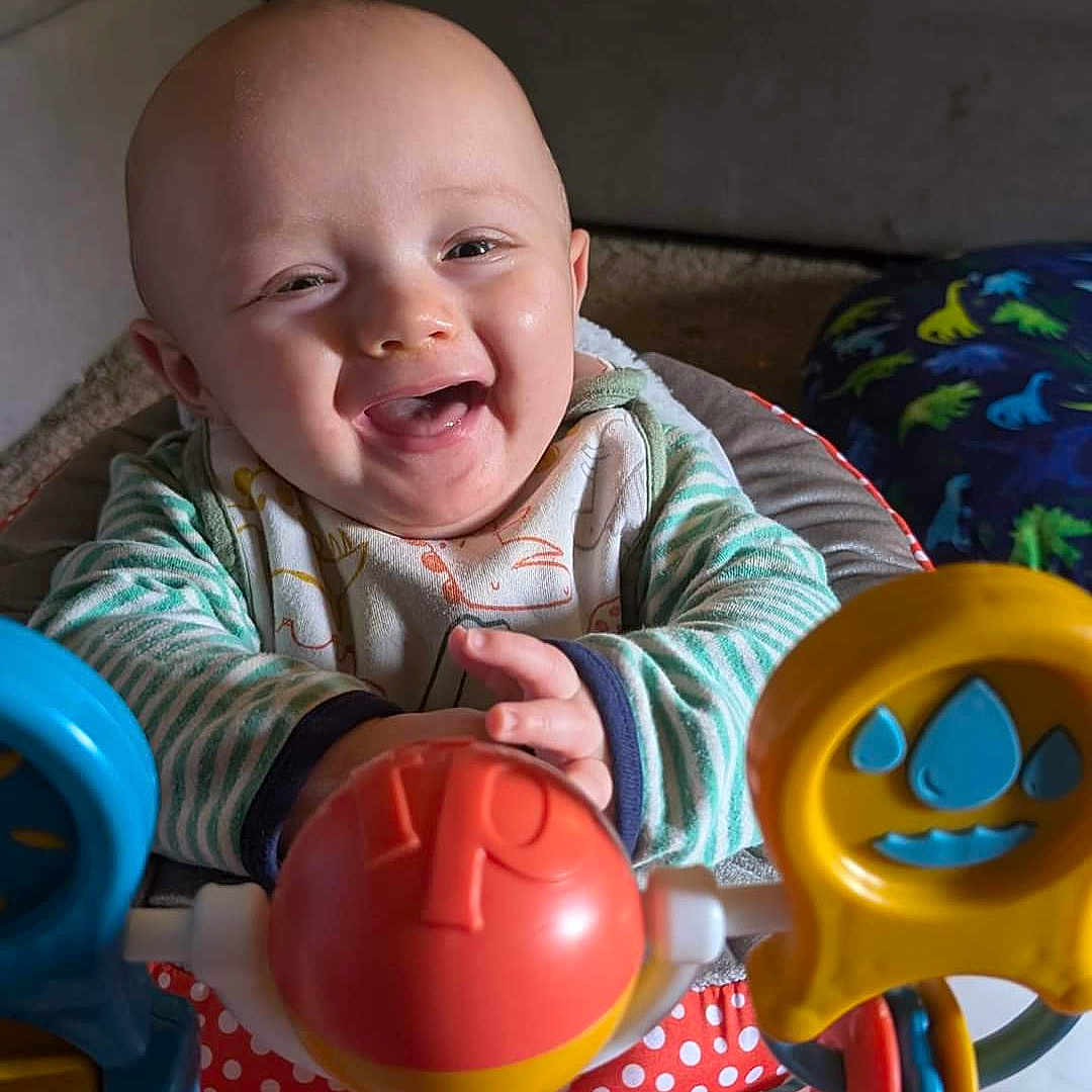 Liam is registered to the contest to win money with this photo: architecture, baby, babylaughing, building, couch, cutlery, face, furniture, happy, head, homedecor, indoors, laughing, person, photography, portrait, sitting, smile, spoon, toy