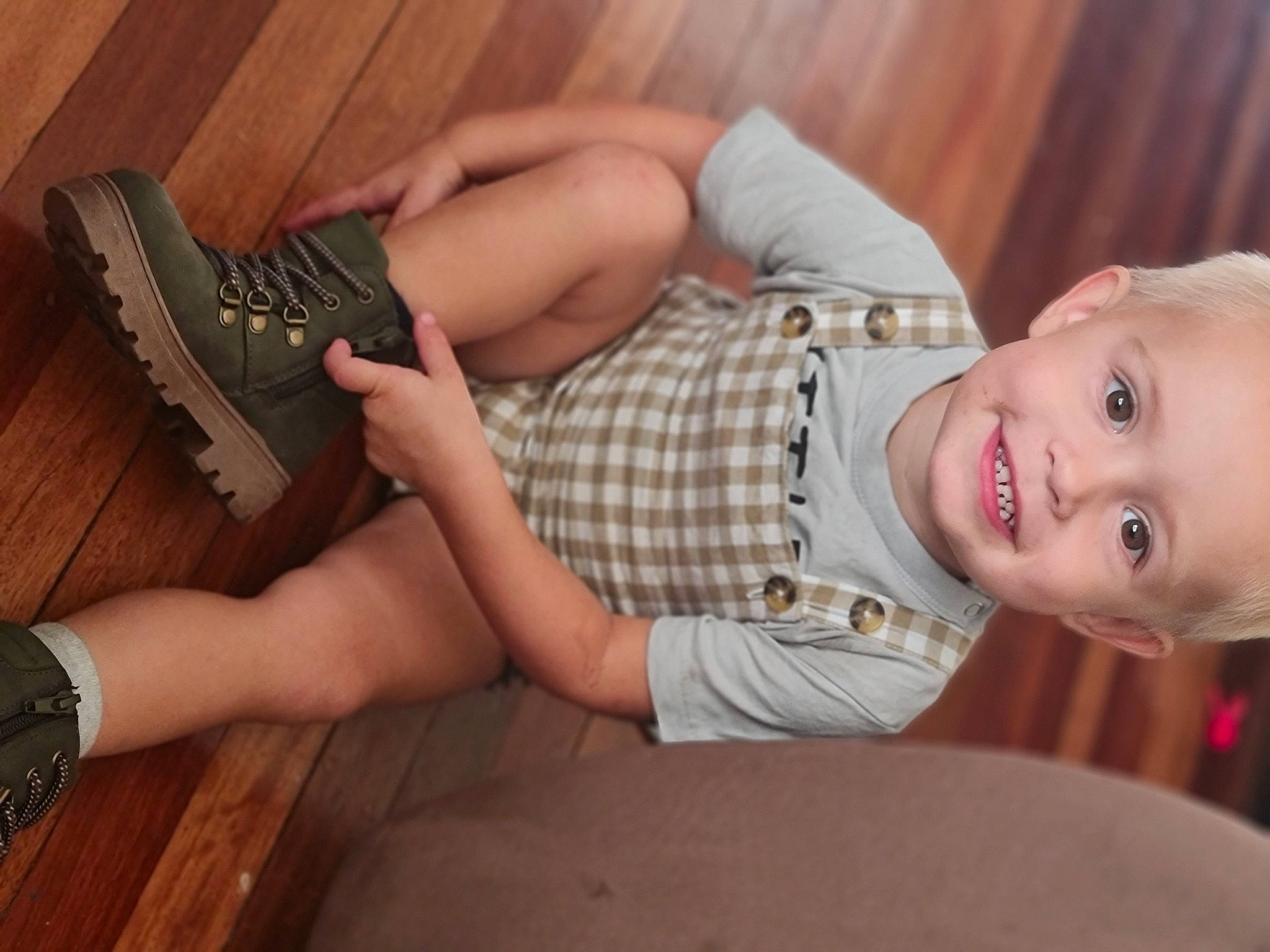 Lochlan is registered to the contest to win money with this photo: baby, black, child, dress, flooring, foot, hardwood, head, human_leg, joy, knee, nail, pattern, person, plaid, skin, smile, sunglasses, thigh, toddler