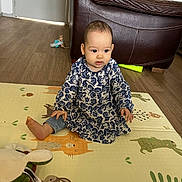 Charlotte participe au concours pour gagner de l'argent avec cette photo : animal_print, baby, child, colorful, cute, dress, floor, furniture, home, indoor, jeans, leather_chair, person, play_mat, plush_toy, room, sitting, toy, wooden_floor, young_child