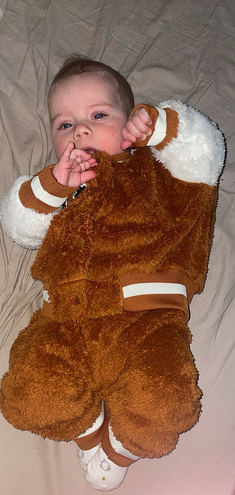 Antonio participe au concours pour gagner de l'argent avec cette photo : arm, baby, baby_toddler_clothing, brown, cheek, ear, eyelash, face, finger, gesture, hand, head, human_body, nose, person, skin, sleeve, textile, thumb, toddler