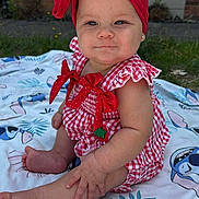 Khalilah joined the competition — help win amazing prizes! baby, blanket, child, cute, earrings, foot, gingham, grass, hand, headband, infant, outdoor, pattern, person, plaid, portrait, red, sitting, smile, summer
