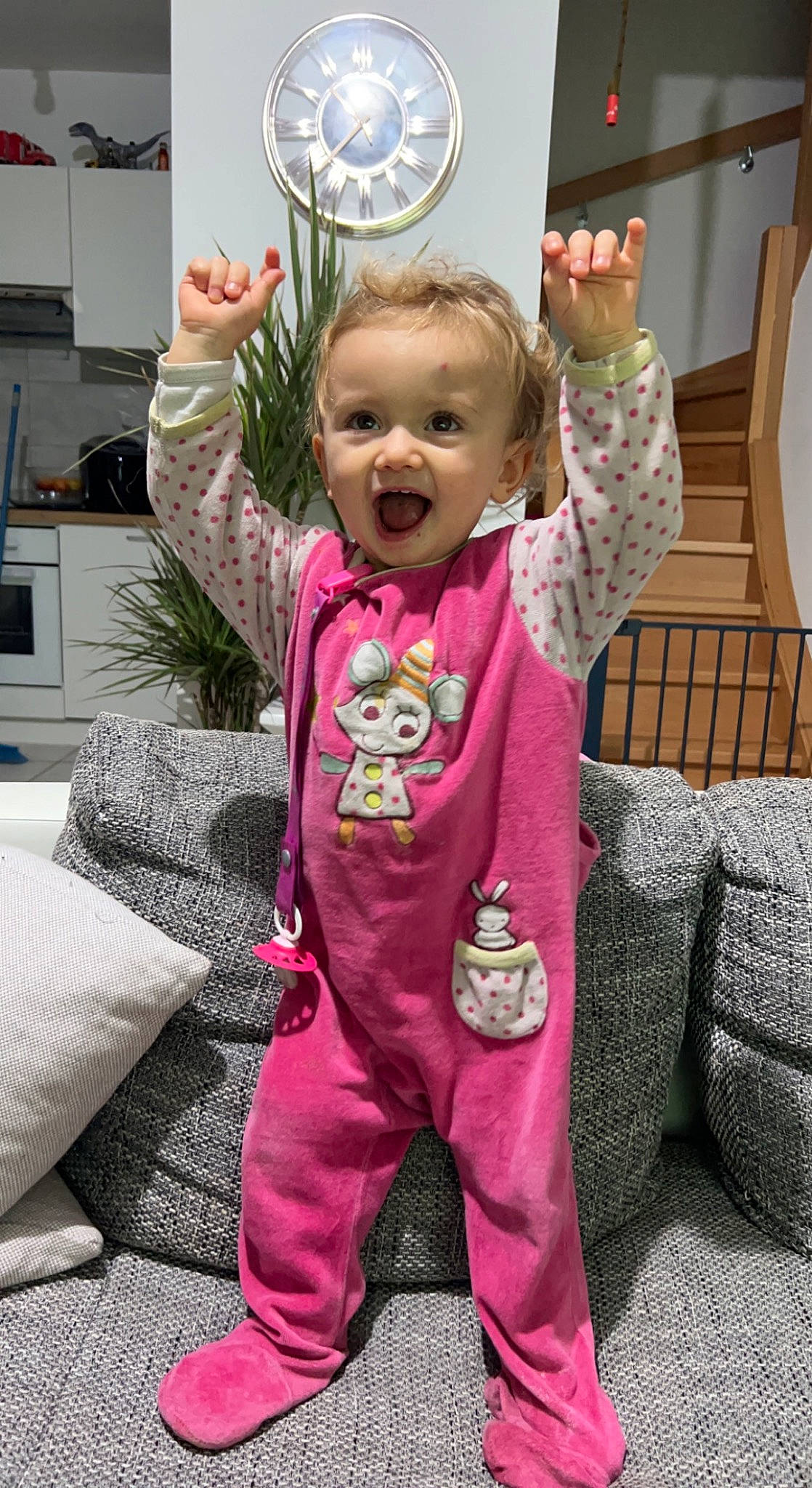Valentina participe au concours pour gagner de l'argent avec cette photo : baby, baby_toddler_clothing, child, clock, couch, event, fun, gesture, happy, home_appliance, magenta, person, pink, purple, sleeve, smile, t_shirt, television, textile, thumb