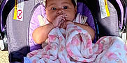 Lilly joined the competition — help win amazing prizes! baby, blanket, baby_carrier, child, headband, outdoor, grass, purple, pink, teddy_bear_pattern, infant, cute, thumb_sucking, cozy, comfort, sunlight, toddler, young_child, clothing, portrait