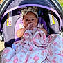 baby, blanket, baby_carrier, child, headband, outdoor, grass, purple, pink, teddy_bear_pattern, infant, cute, thumb_sucking, cozy, comfort, sunlight, toddler, young_child, clothing, portrait