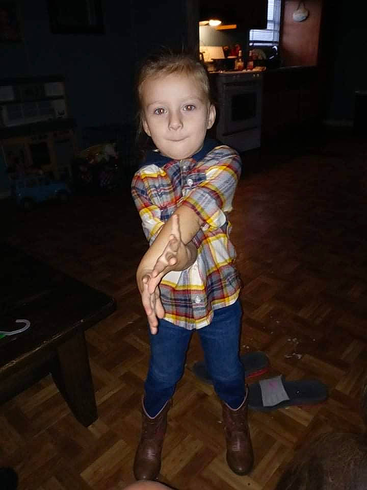 Savannah is registered to the contest to win money with this photo: child, face, flash_photography, floor, flooring, fun, fur, hardwood, human_leg, knee, pattern, person, plaid, room, sitting, sleeve, standing, tartan, television, toddler