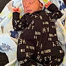baby, blanket, child, clothing, couch, cozy, cute, fabric, face, footed_pajamas, headwear, indoor, infant, newborn, onesie, patterned_clothing, peaceful, resting, sleeping, soft