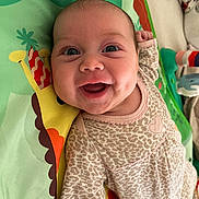 Stella joined the competition — help win amazing prizes! baby, smiling, infant, play_mat, giraffe, animal_print, leopard_pattern, heart, cute, child, happy, indoors, clothing, face, person, portrait, lying_down, colorful, toy, playtime