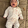 baby, infant, child, smiling, laughing, portrait, lying_down, white_outfit, headband, bow, pacifier, quilt, blanket, indoor, cozy, happy, face, clothing, nursery, photography