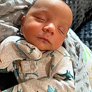 Colter joined the competition — help win amazing prizes! baby, newborn, sleeping, infant, onesie, dinosaur_pattern, blanket, cozy, child, peaceful, soft, cute, portrait, closeup, resting, human, face, skin, sleep, comfort