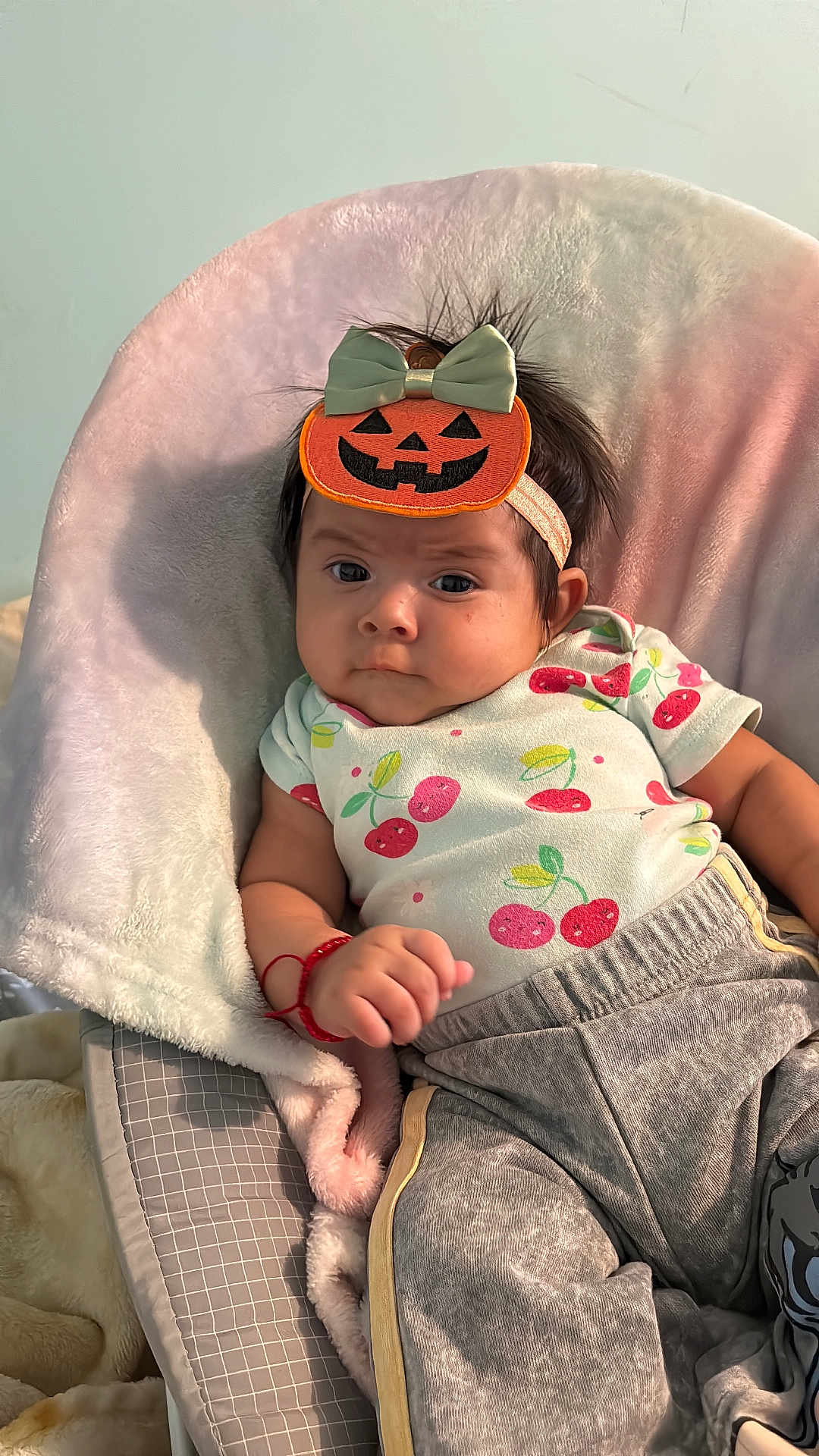 Keitlyn Ramírez joined the competition — help win amazing prizes! baby, child, infant, pumpkin_headband, cute, soft_cushion, cherry_pattern, shirt, pants, red_bracelet, indoor, portrait, expression, comfortable, seated, clothing, headwear, person, young, cozy
