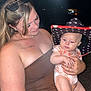Raya is registered to the contest to win money with this photo: woman, baby, child, hat, cowboy_hat, holding, portrait, tattoo, flash, night, outdoor, person, skin, clothing, face, eyelashes, glasses, expression, cute, family