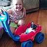 brick_fireplace, cat, child, colorful, couch, cute, floor, fun, furniture, girl, happy, home, indoor, living_room, pet, playful, small_animal, smiling, toy_car, wood_floor