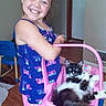 Oreo joined the competition — help win amazing prizes! barefoot, basket, black_and_white_cat, casual_clothing, cat, child, cute, domestic, furniture, girl, happy, holding, indoor, pet, pink, relaxed, shorts, smiling, tank_top, wooden_floor