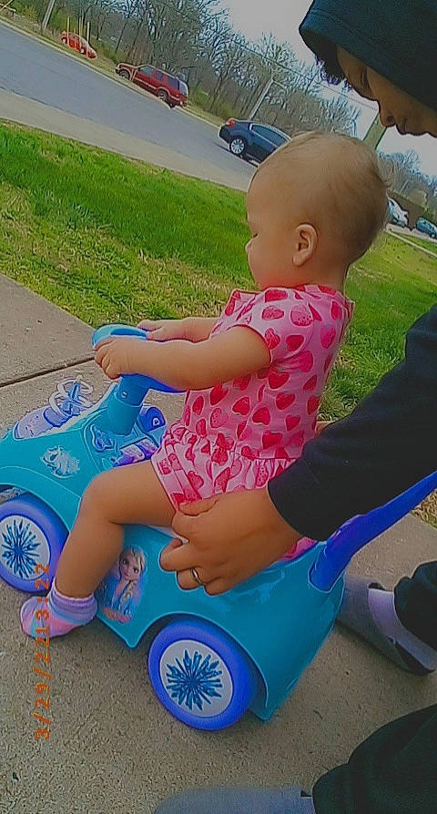 Amarianna joined the competition — help win amazing prizes! baby_toddler_clothing, electric_blue, fun, grass, happy, human_leg, lap, leisure, person, plant, play, recreation, riding_toy, shoe, sitting, thigh, tire, toddler, toy, vehicle