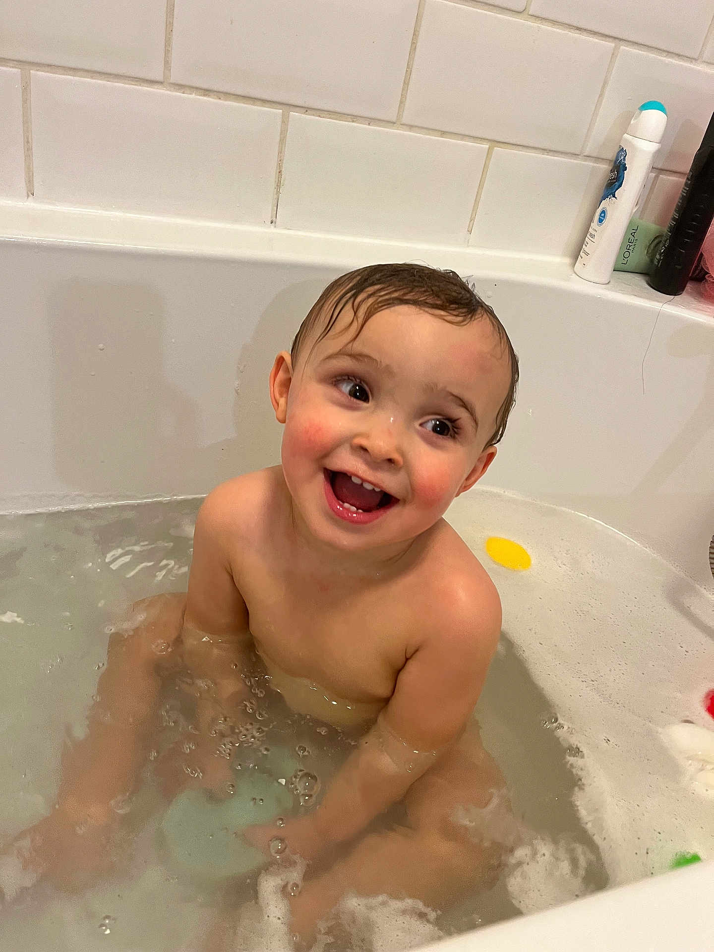 Ollie joined the competition — help win amazing prizes! toddler, child, bathtub, bath, water, bubbles, wet_hair, smiling, happy, skin, bathroom, tiles, soap, personal_care, sitting, playful, young_child, indoors, cute, joyful