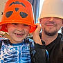 Ollie is registered to the contest to win money with this photo: child, adult, bucket, hat, orange, white, smile, funny_face, indoor, curtain, window, long_sleeve, blue_shirt, facial_hair, playful, happy, person, casual_clothing, family, goofy