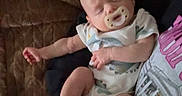 Haze joined the competition — help win amazing prizes! baby, infant, sleeping, pacifier, couch, blanket, cushion, indoors, portrait, sitting, onesie, clothing, barefoot, leg, arm, cozy, dim_lighting, home, relaxed, nap