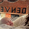 newborn, baby, infant, child, face, smiling, sleepy, bundled, blanket, swaddled, portrait, indoor, cozy, textile, woven_background, bed, lying_down, cute, photography, family