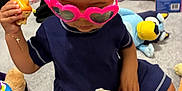 Gianna is registered to the contest to win money with this photo: toddler, child, indoor, toys, sunglasses, pink, heart_shaped, carpet, playtime, blue_dress, hand, toy_figure, stuffed_animal, floor, person, casual_clothing, playroom, candid, cute, baby
