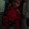 baby, baby_girl, blurry, car_seat, child, child_in_car_seat, clothing, cute, dim_lighting, headwear, indoors, infant, infant_clothing, person, portrait, red_bow, red_clothing, seat, sitting, young_child
