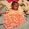 baby, infant, pink_dress, blanket, bed, pillow, sleepy, indoor, person, portrait, cute, child, soft_texture, cozy, relaxed, newborn, clothing, skin, head, lying_down