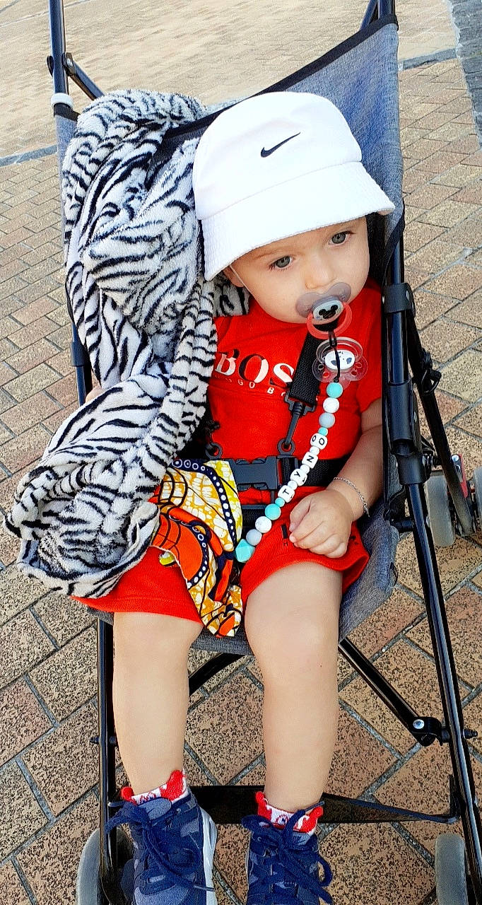 Tyno participe au concours pour gagner de l'argent avec cette photo : baby, baby_carriage, baby_products, cap, child, child_model, clothing, hat, headgear, headwear, helmet, human_leg, leg, outerwear, person, product, shoe, sleeve, sun_hat, thigh