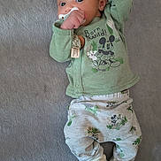 Maddox joined the competition — help win amazing prizes! baby, infant, pacifier, green_clothing, mickey_mouse, lying_down, blanket, cute, small_hands, soft_texture, socks, patterned_pants, child, adorable, young, portrait, indoor, sleepwear, relaxed, curious_eyes