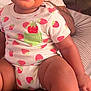 adult, baby, bed, child, clothing, cute, face, happy, indoor, infant, lap, onesie, person, pillow, portrait, sitting, skin, smile, sock, strawberry_pattern