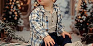 Néoh a rejoint le concours — aidez-le/la à gagner de superbes lots ! toddler, child, plaid_blanket, socks, buttoned_shirt, lanterns, holiday_decor, christmas_trees, indoors, festive, curious_expression, seated, winter_clothing, portrait, soft_lighting, background_bokeh, cozy, cute, young_child, holiday_season
