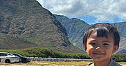 Weston Aydyn is registered to the contest to win money with this photo: boy, car, casual_clothing, child, clouds, daylight, field, grass, happy, landscape, mountains, nature, outdoor, person, portrait, scenic, sky, smile, sunny, young