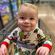 Braxton joined the competition — help win amazing prizes! baby, child, shopping_cart, pajamas, holiday_theme, smiling, face, hand, indoor, supermarket, cute, infant, seatbelt, clothing, person, retail, store, blurry_background, expression, young