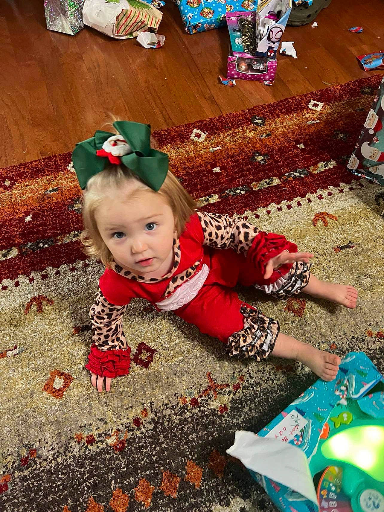 Riley is registered to the contest to win money with this photo: baby, baby_toddler_clothing, carmine, child, christmas, christmas_eve, event, fictional_character, flooring, fun, grass, happy, holiday, people_in_nature, person, play, soil, toddler, tradition, tree