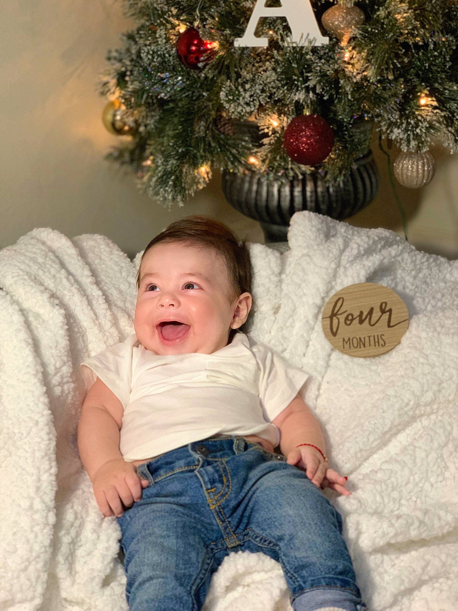 Aaron is registered to the contest to win money with this photo: baby, baby_toddler_clothing, child, christmas_decoration, christmas_ornament, christmas_tree, comfort, event, happy, head, holiday, holiday_ornament, jeans, lap, ornament, person, sitting, smile, toddler, tree