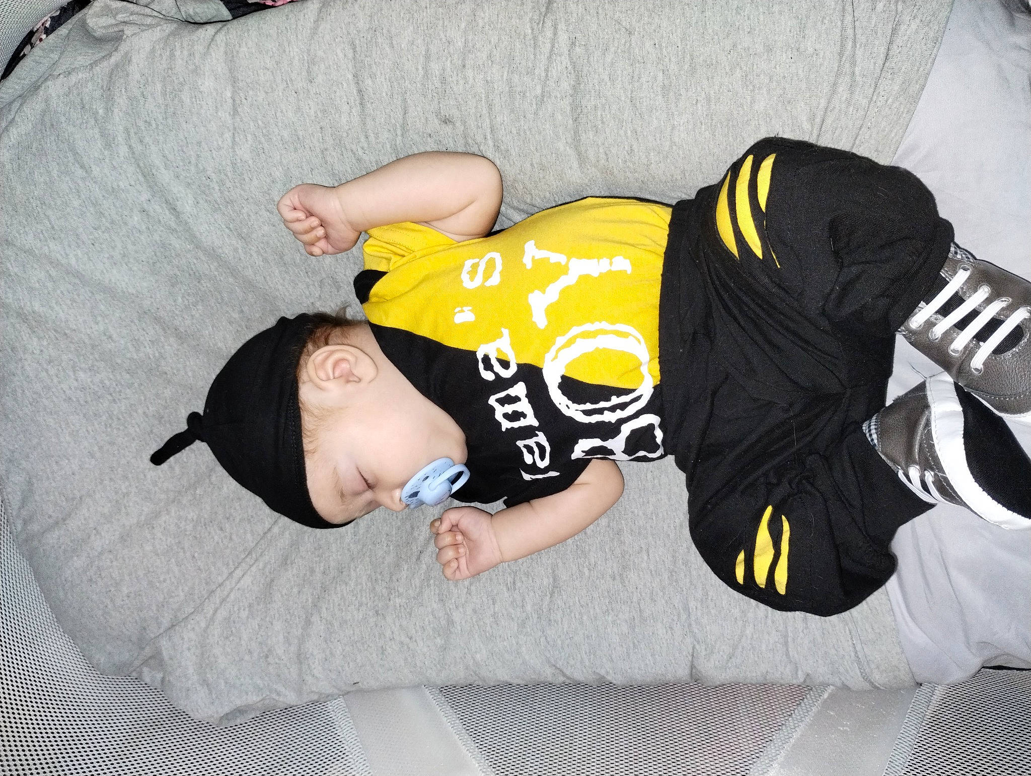Carlos Jr is registered to the contest to win money with this photo: baby_toddler_clothing, child, comfort, elbow, flooring, font, fun, human_leg, knee, leg, linens, nap, pattern, person, room, sitting, sleeve, sock, sportswear, t_shirt