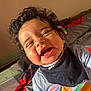 child, toddler, curly_hair, smiling, laughing, indoor, bed, clothing, bib, happy, person, face, cute, young_child, portrait, casual, expression, skin, baby, home