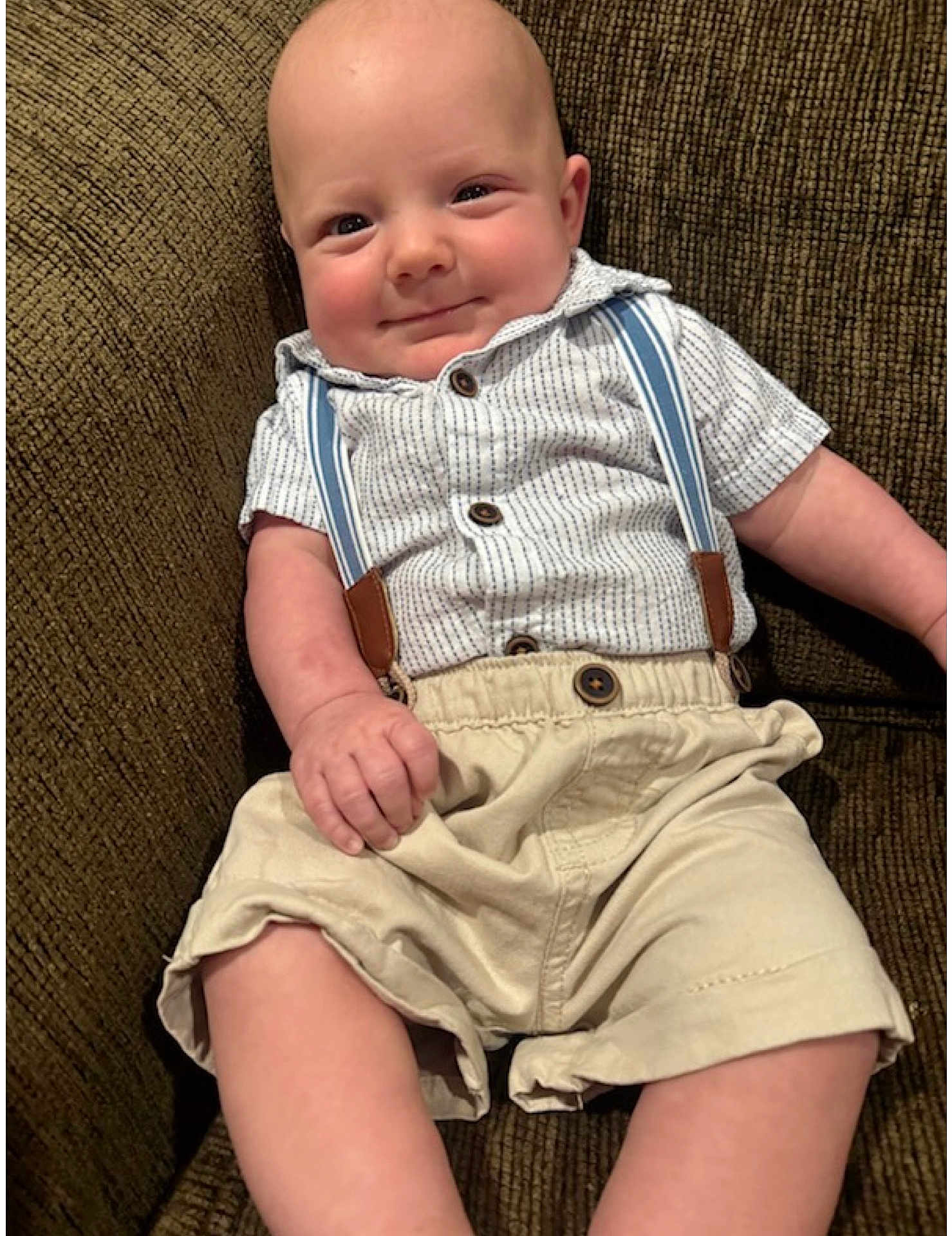 Elliott joined the competition — help win amazing prizes! baby, infant, smile, face, clothing, shirt, suspenders, shorts, couch, furniture, person, skin, hand, leg, seated, cute, happy, indoors, portrait, child