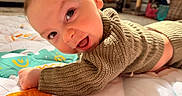 Luca joined the competition — help win amazing prizes! baby, bright_eyes, child, colorful, cozy, cute, face, happy, indoor, infant, knitted_sweater, lying_down, person, playful, portrait, quilt, smiling, toddler, warm, young