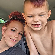 Nikolai is registered to the contest to win money with this photo: woman, child, car, selfie, smile, tattoo, short_hair, mohawk, blue_eyes, casual_clothing, shirtless, indoor, seat, person, hair_up, happy, family, portrait, closeup, natural_light