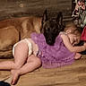Hazel is registered to the contest to win money with this photo: child, toddler, dog, sleeping, floor, wooden_floor, purple_dress, pet, animal, nap, indoor, cozy, friendship, resting, cute, child_and_dog, young_child, domestic_animal, comfort, trust
