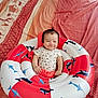 Hélios a rejoint le concours — aidez-le/la à gagner de superbes lots ! baby, infant, smile, inflatable_ring, bed, blanket, pattern, whale, swordfish, red, white, clothing, cute, child, indoor, person, happy, rest, seat, relax