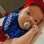 Willow is registered to the contest to win money with this photo: baby, infant, pacifier, headband, bow, blue_clothing, red_bow, close_up, lying_down, cute, child, face, hand, soft_texture, portrait, indoors, bright_eyes, peaceful, adorable, young_child