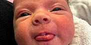 Willow is registered to the contest to win money with this photo: baby, newborn, face, tongue, skin, head, eyes, blanket, towel, closeup, infant, person, expression, cute, soft, indoors, human, sleepy, cheeks, warm