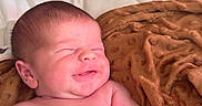 Colton is registered to the contest to win money with this photo: baby, newborn, smile, blanket, bottle, infant, sleepy, skin, lying_down, child, cute, peaceful, soft, indoors, young, portrait, resting, human, newborn_baby, baby_bottle